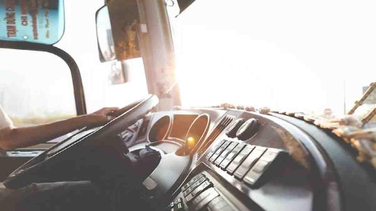 person driving steering wheel of a transport truck