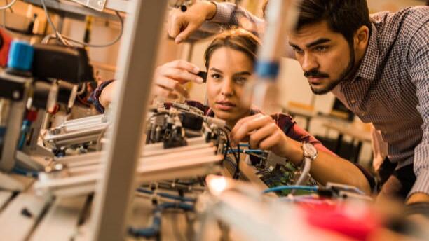 An electrician apprentice works with their mentor
