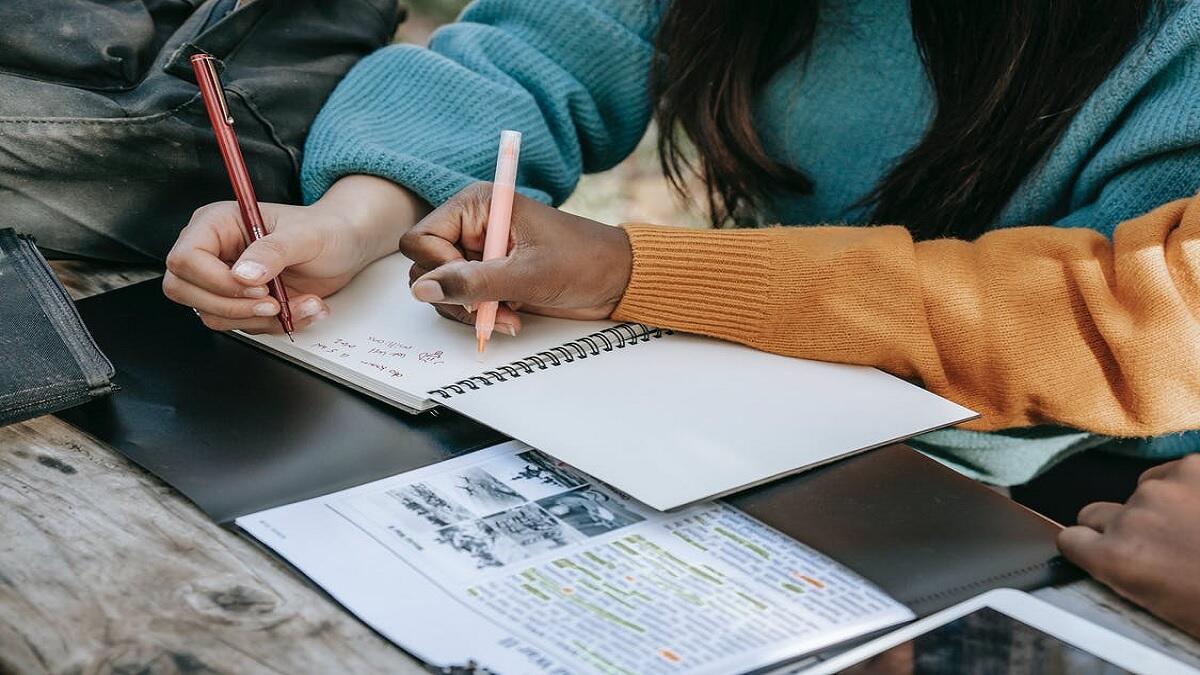 Diverse schoolgirls taking notes