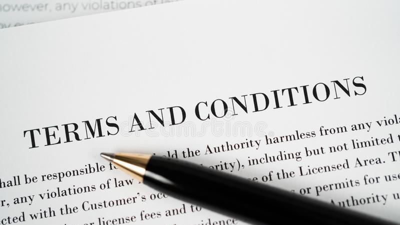 A zoomed in page of terms and conditions with a pen on top of it