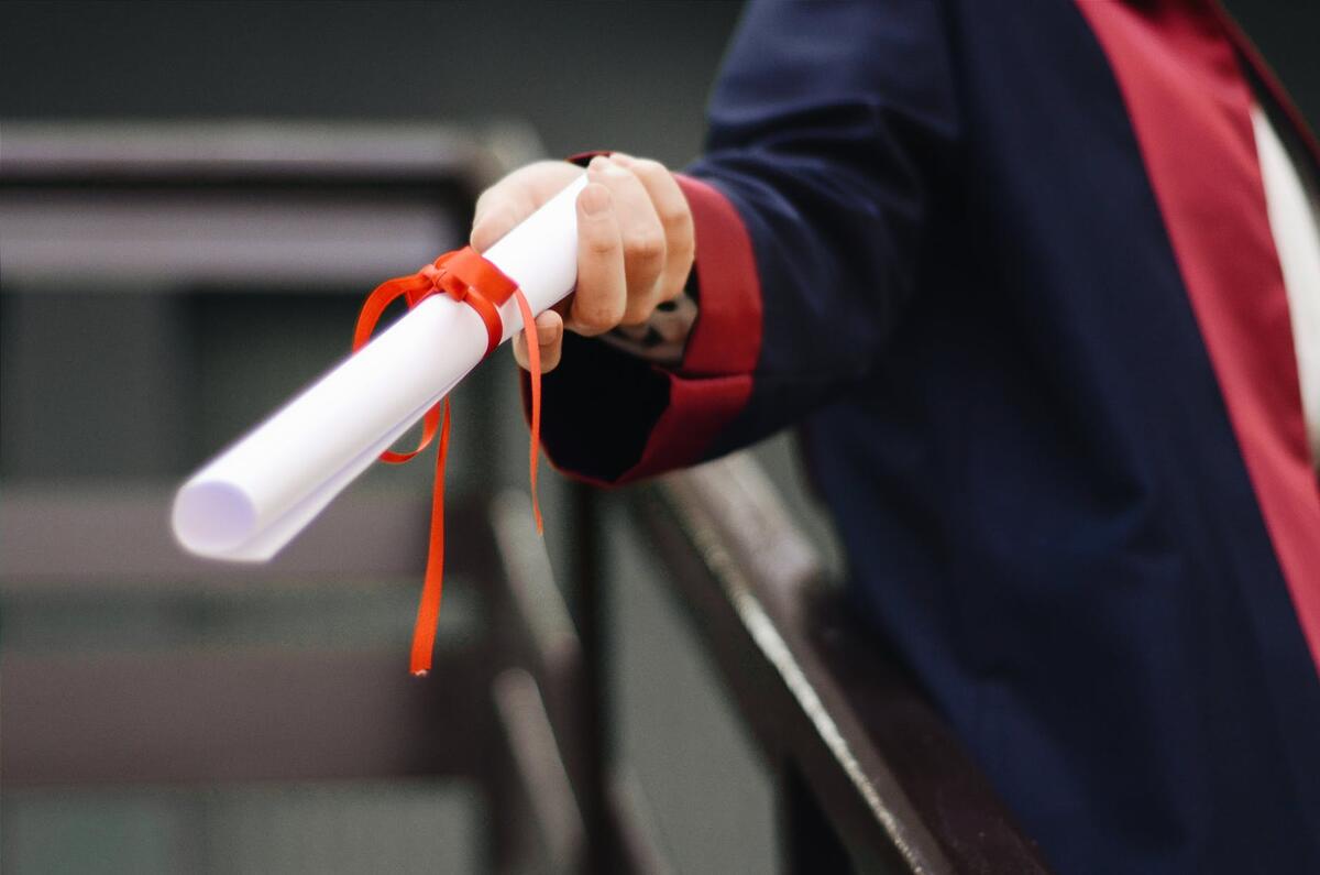 handed copy of certificate tied with a red ribbon.
